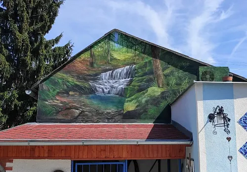 Štít domu s motivem lesa, potůčku a jezírka
